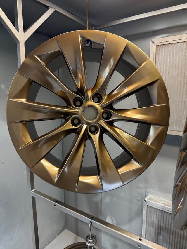 Turbine-style wheel powder coated in bronze, hanging in the booth